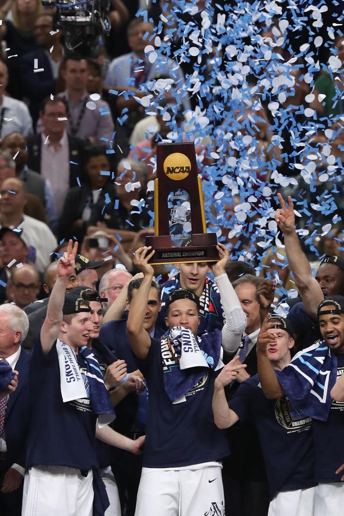 Villanova players celebrating under confetti with the NCAA championship trophy